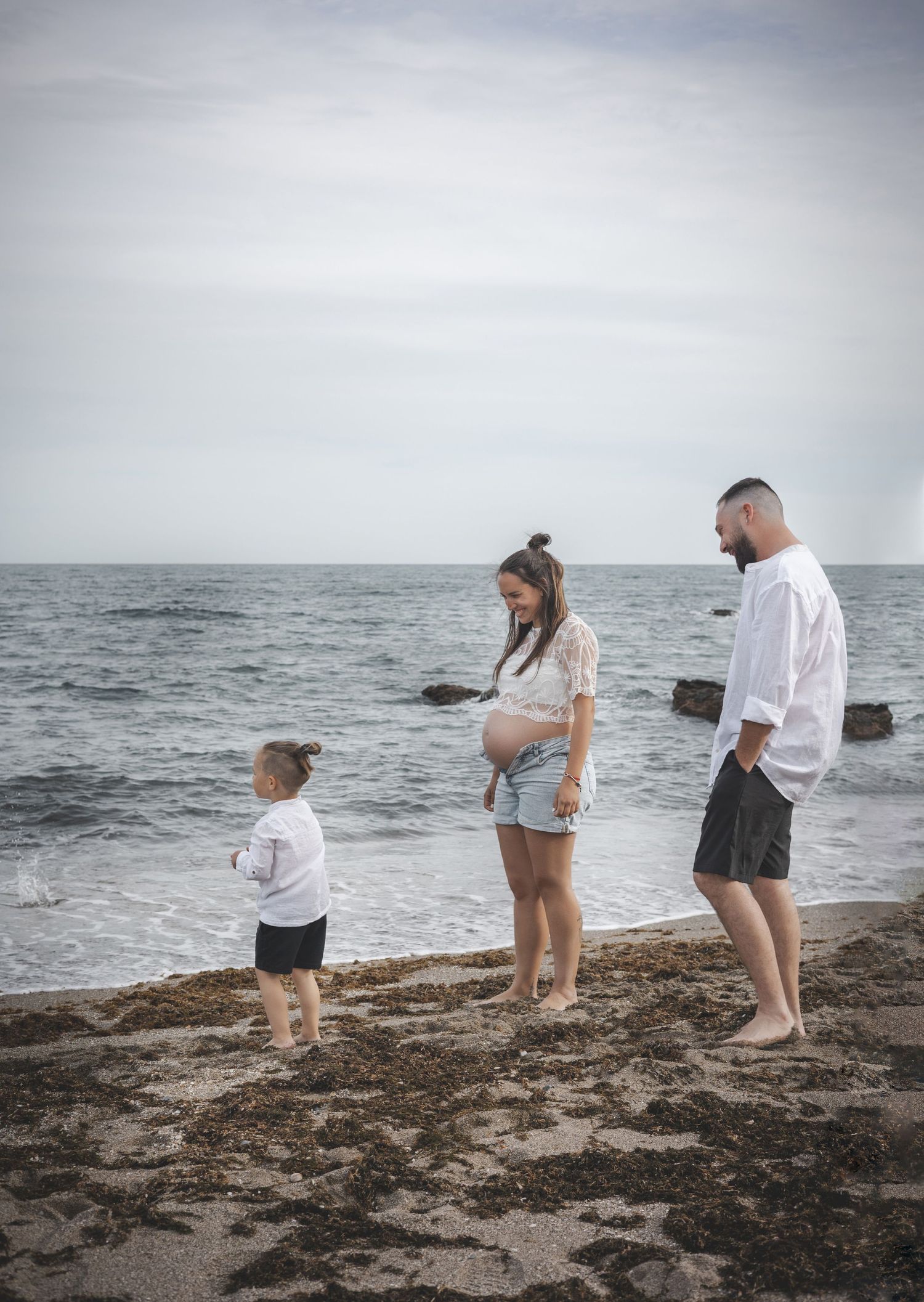 Familia esperando un bebé junto al mar