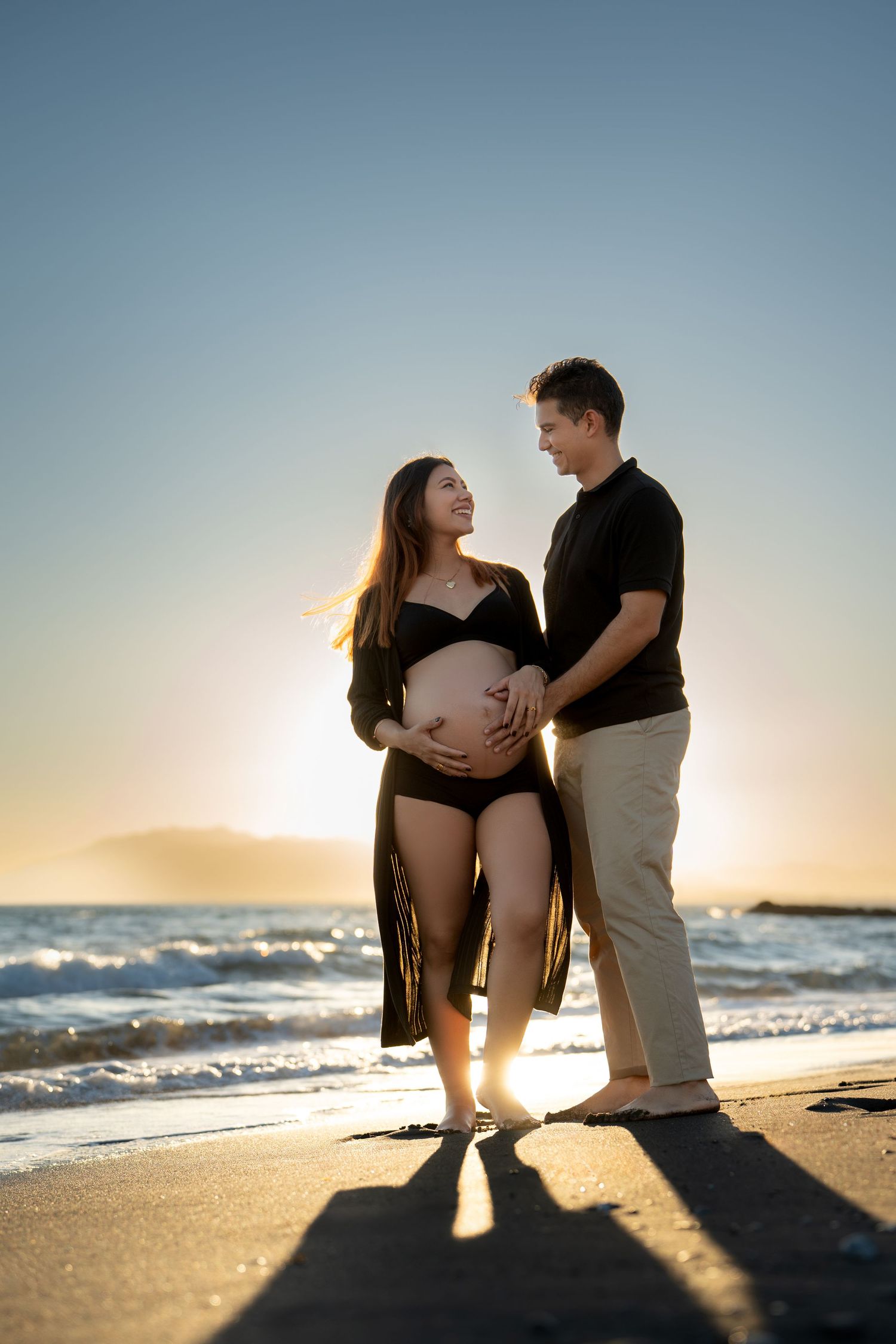 Pareja durante una sesión de embarazo al atardecer