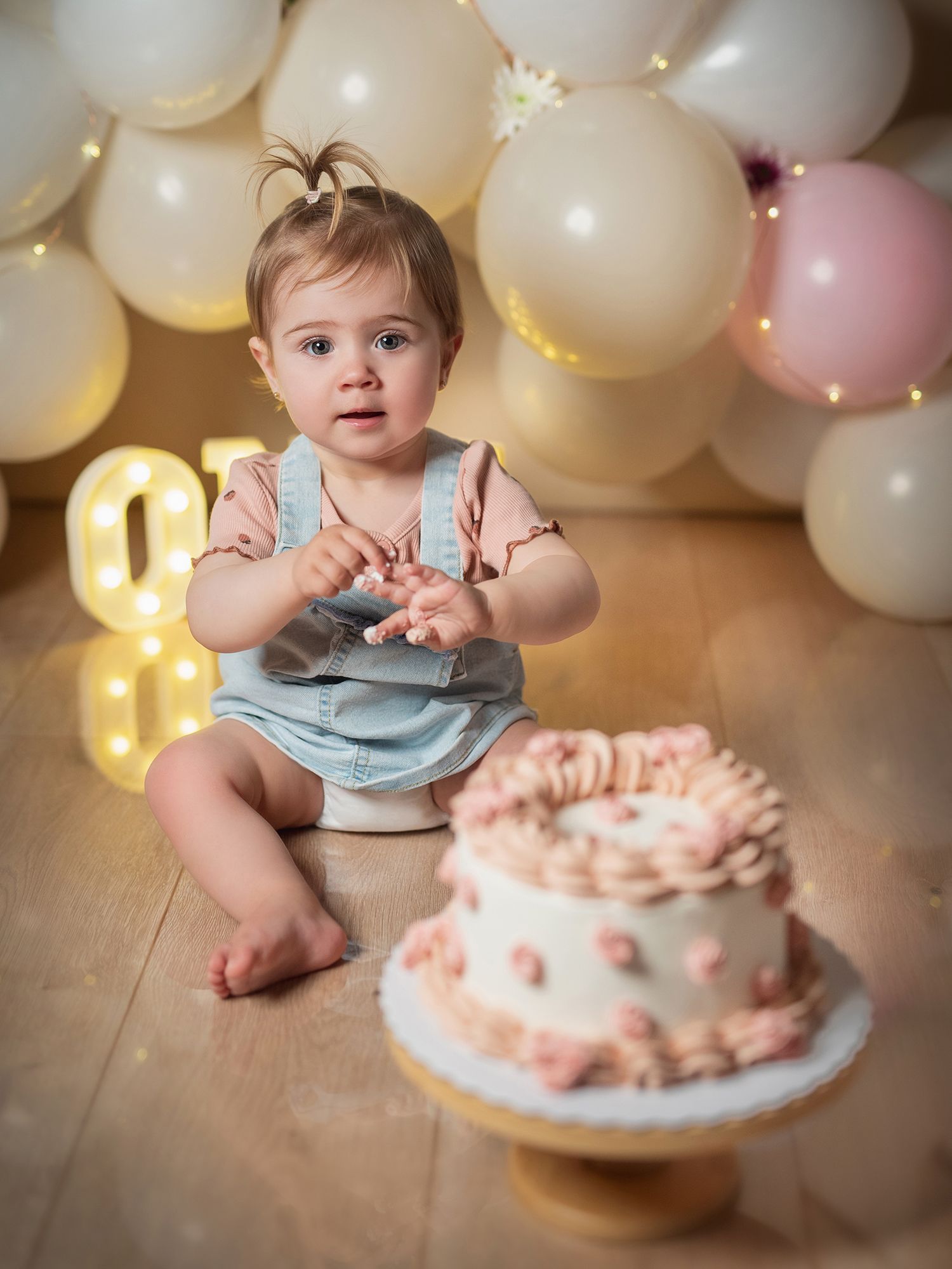 Bebé en una sesión de primer cumpleaños con tarta